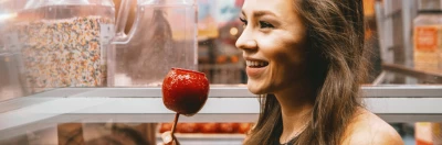 Woman enjoying a candy apple in a fair setting