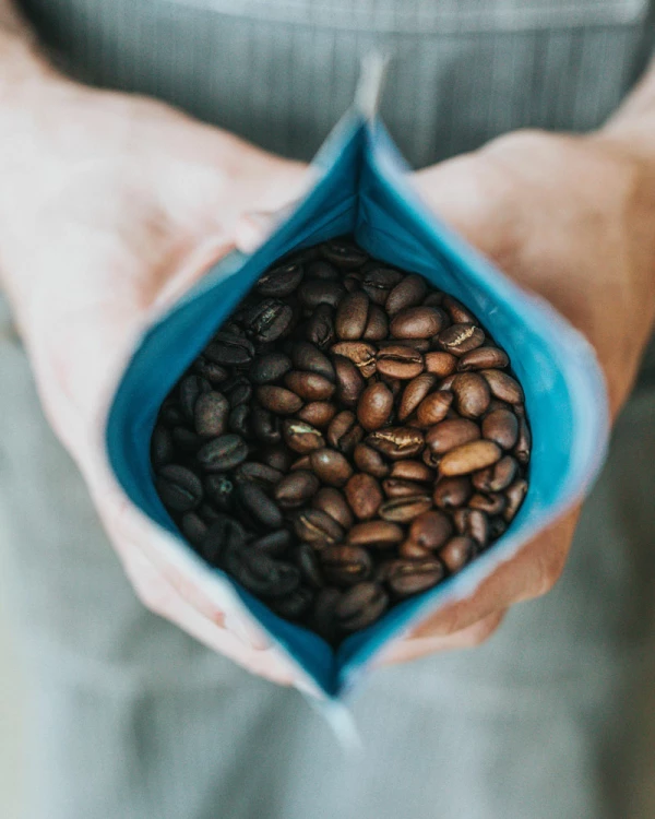 Person holding Custom Printed Coffee Bag with Roasted Beans