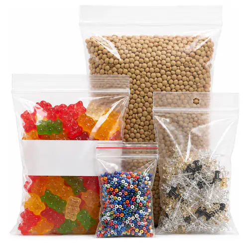 Four clear zip-lock bags in graduated sizes filled with candy, beans, beads, and hardware.