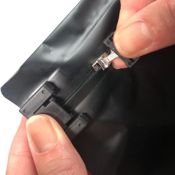 8 x 6 + 2.36 Child Proof Exit Bags Black 8 x 6 + 2.36 Child Proof Exit Bags Fingers Pulling Zipper Open