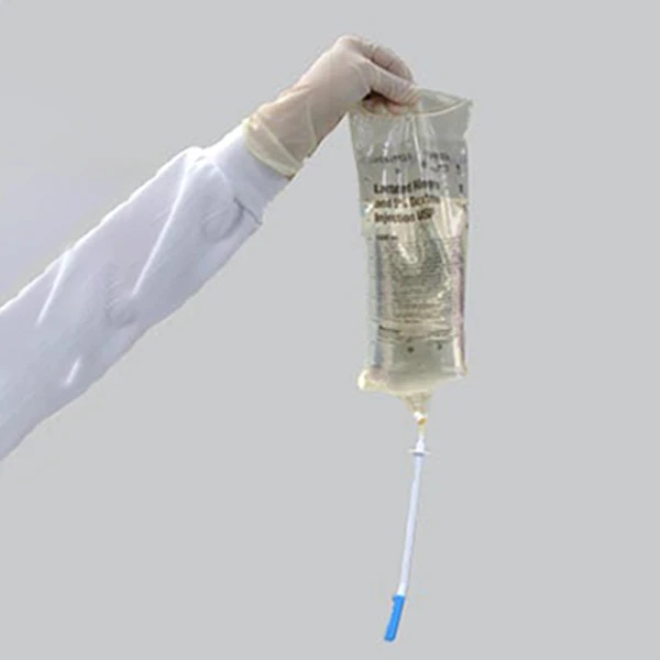 3. Firmly insert the spike into the IV bag outlet, then remove the packaging from the spout. Medical professional holding I±V bag with spike end of decanter inserted