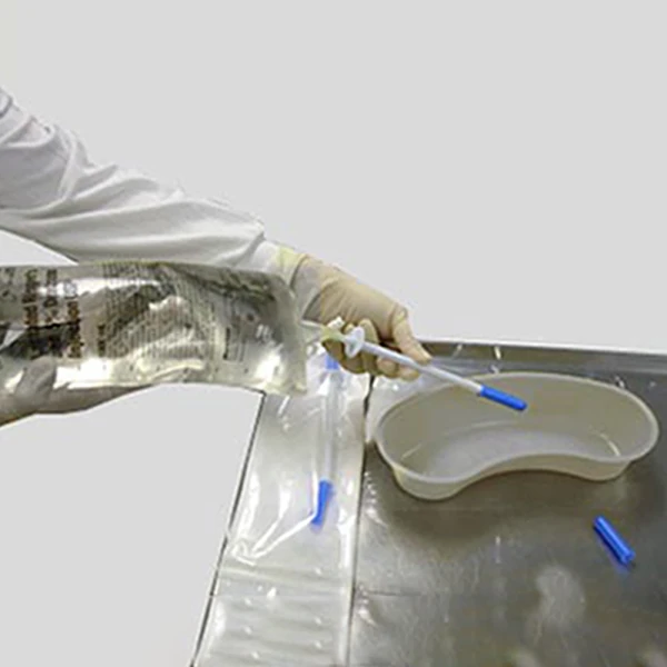 2. Hold the product (still in the container pouch) and remove the protective cap from the spiked end. Medical professional removing protective cap off of IV