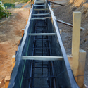 Black plastic sheeting being used to mold concrete foundation